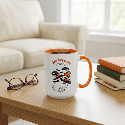 Ceramic Halloween accent mug featuring a ghost wearing a witch hat surrounded by books and bats with the phrase "Just One More Chapter," available in orange and black accent colors in 11oz and 15oz sizes.
