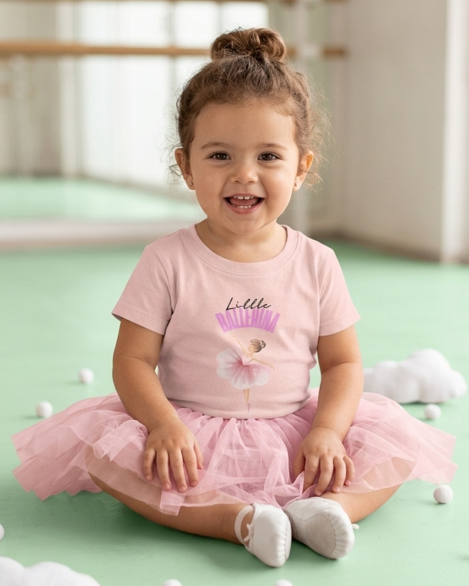 Tddler wearing pink little ballerina t-shirt and a tutu

