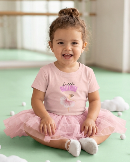 Tddler wearing pink little ballerina t-shirt and a tutu
