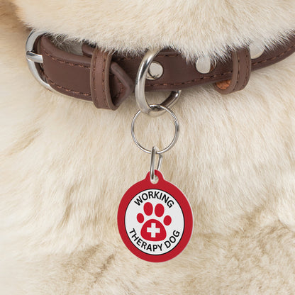 Red personalized Working Therapy Dog ID tag featuring a paw print medical symbol on the front and custom contact information on the back